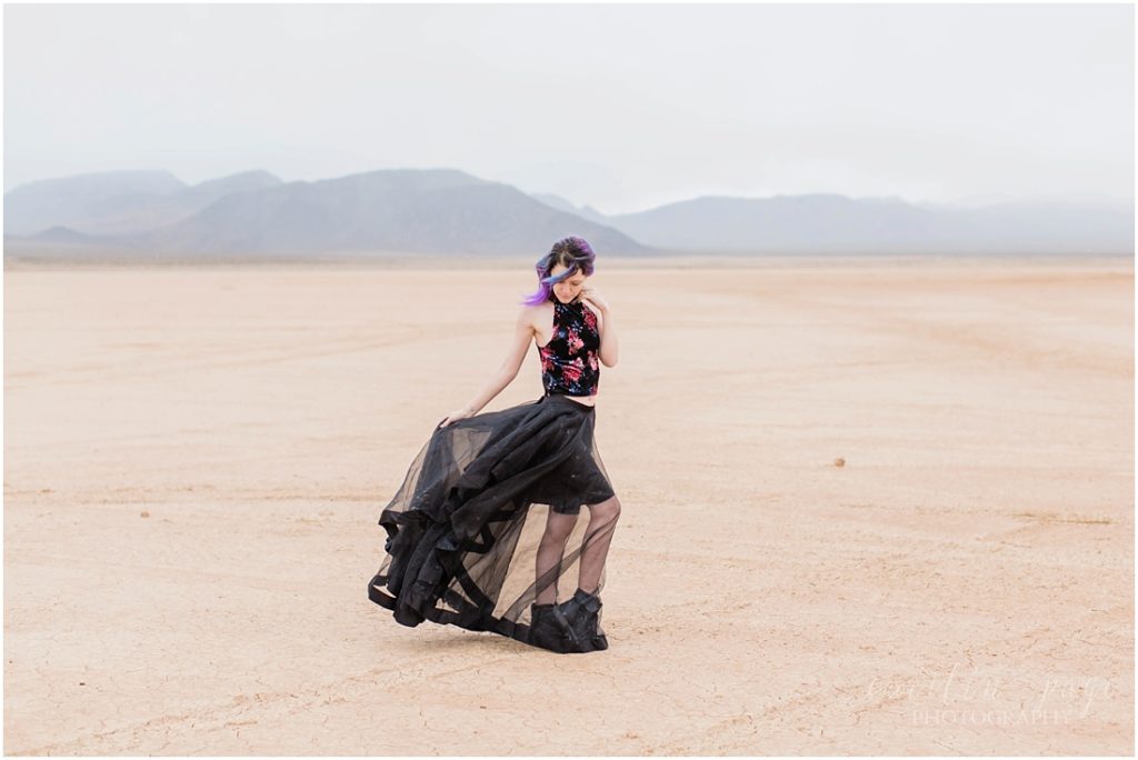 Girl with floral top and black skirt in desert