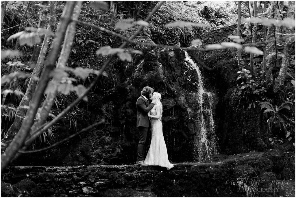 black and white image of couple at waterfall