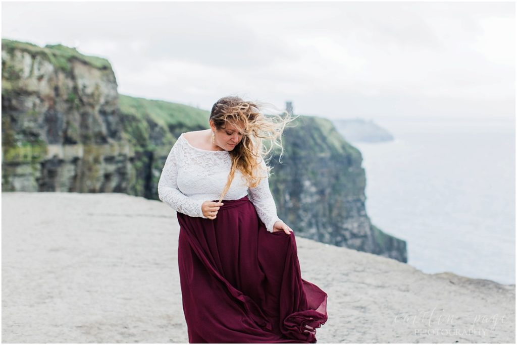 girl in maroon skirt on cliffs of moher
