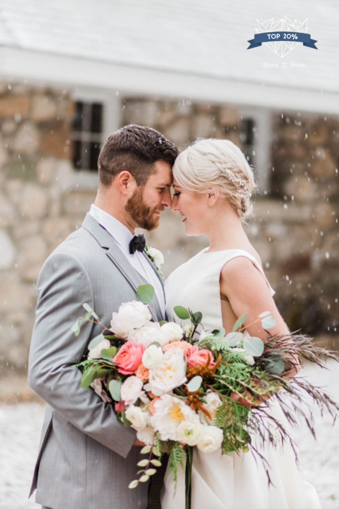 Bride and groom with wedding bouquet during snowstorm