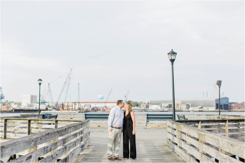 man and woman kissing on pier