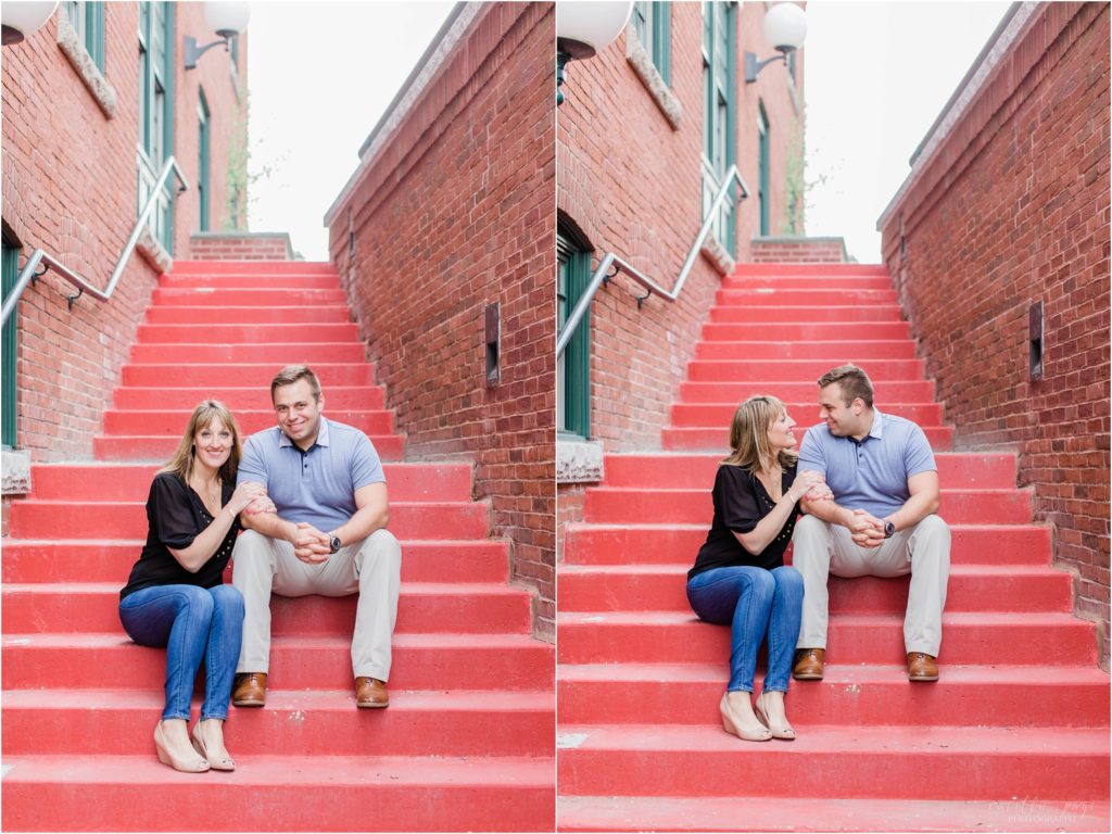 man and woman sitting on red stairs
