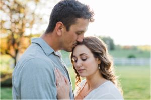 man kissing woman's head
