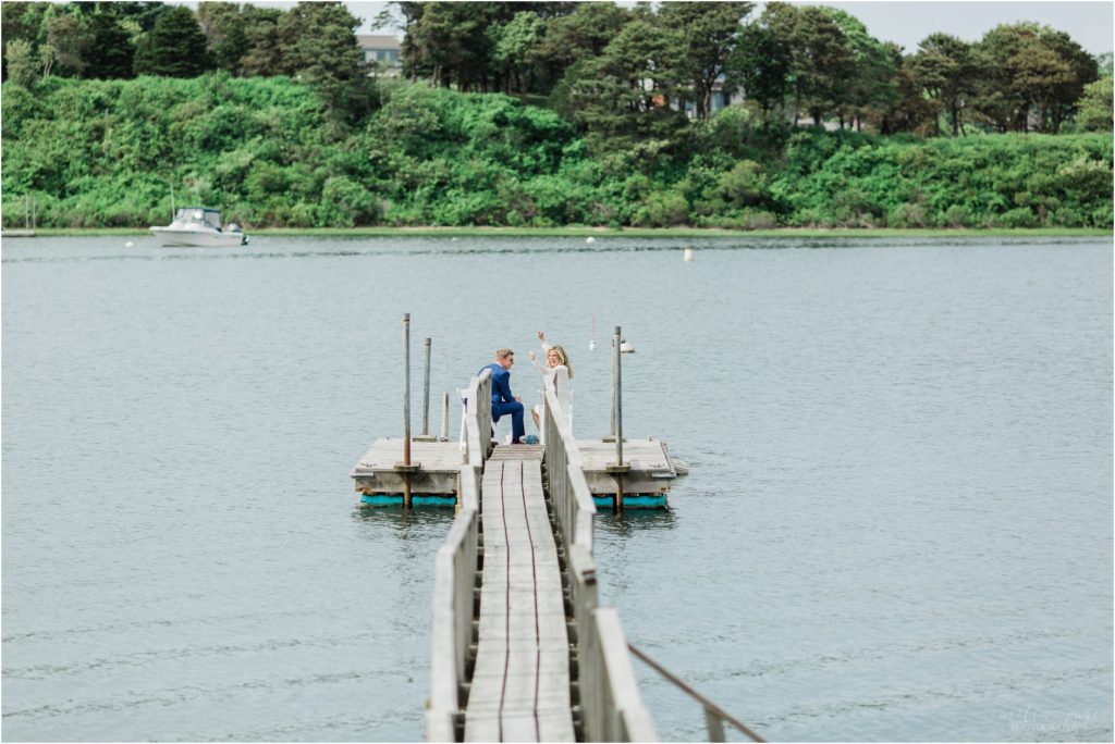 bride and groom sitting on dock