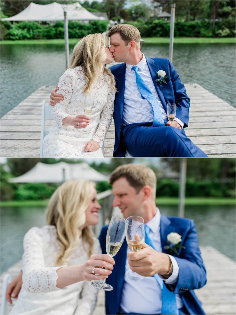 bride and groom with champagne sitting on dock