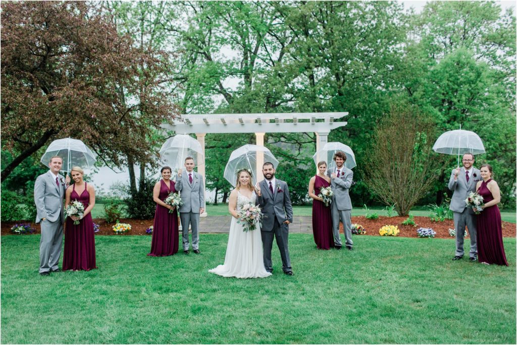 bridal party with bride and groom and umbrellas