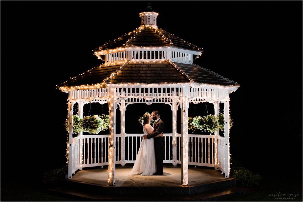 bride and groom outside at night under gazebo