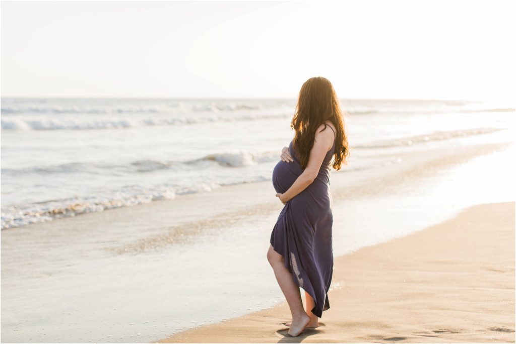 pregnant woman looking out at ocean