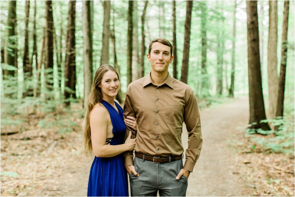 man and woman standing in woods