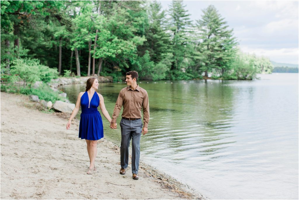 man and woman walking by lake