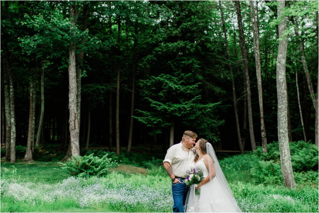 bride and groom kissing in woods
