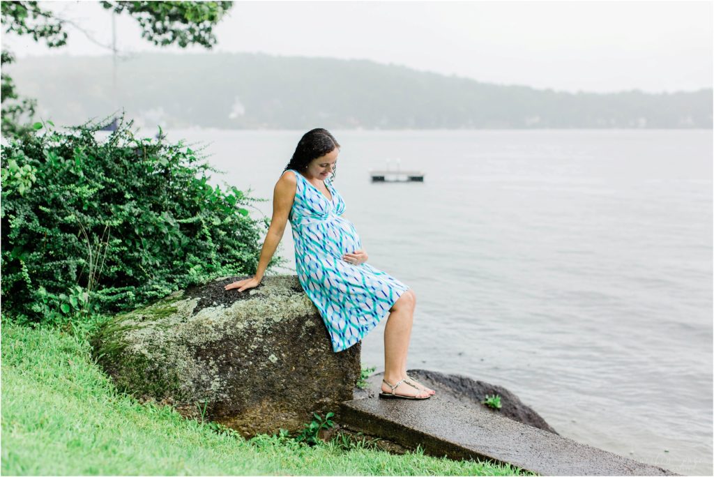 pregnant woman sitting at lake winnipesaukee