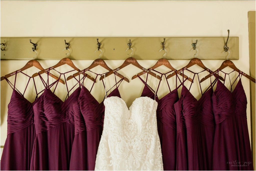 wedding dress and bridesmaids dresses hanging on matching hangers