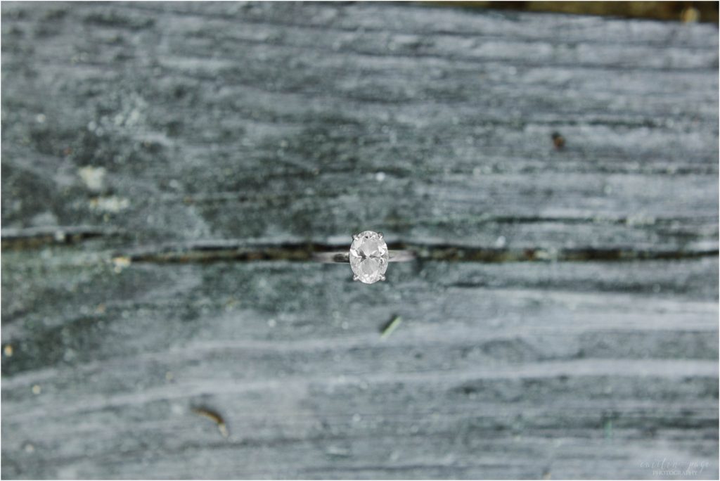 oval cut engagement ring on wooden dock