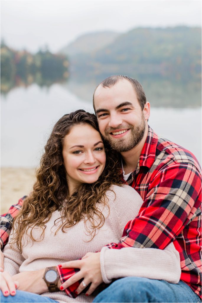 couple sitting on beach fall engagement session