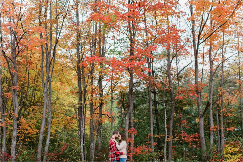 couple standing together under fall colors