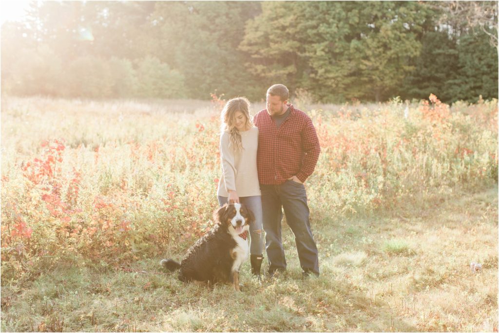 couple standing with their dog in field engagement session effingham new hampshire