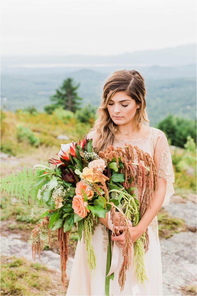 woman holding bouquet on top of mountain