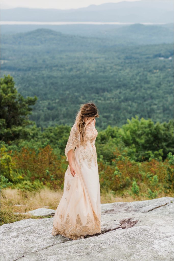 woman in cream dress on top of mountain