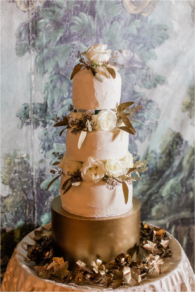 wedding cake in front of hand painted backdrop