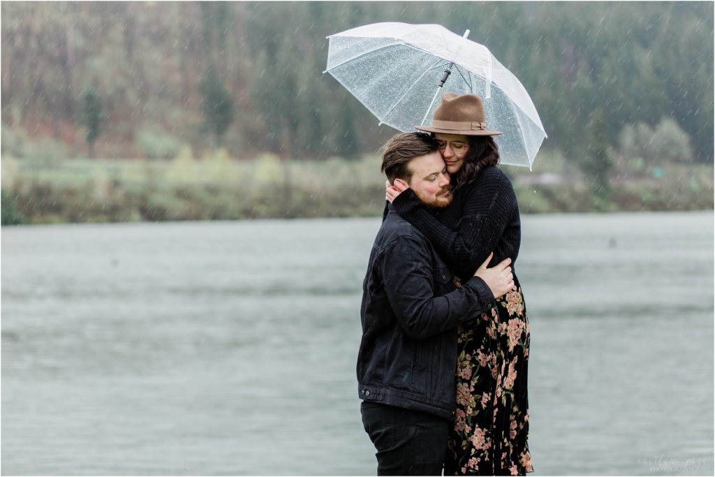 couple hugging in rain under umbrella Oregon