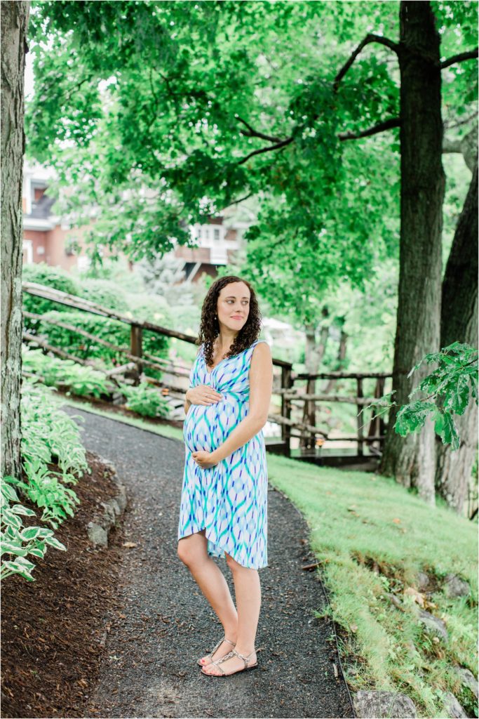 pregnant woman standing under trees