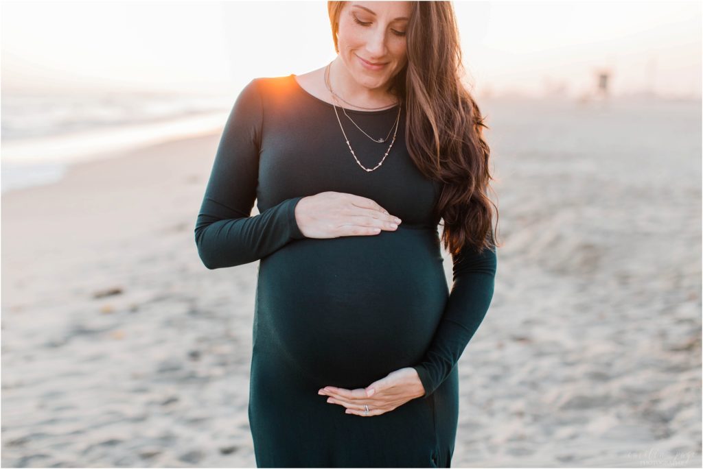 pregnant woman in red dress at beach sunset