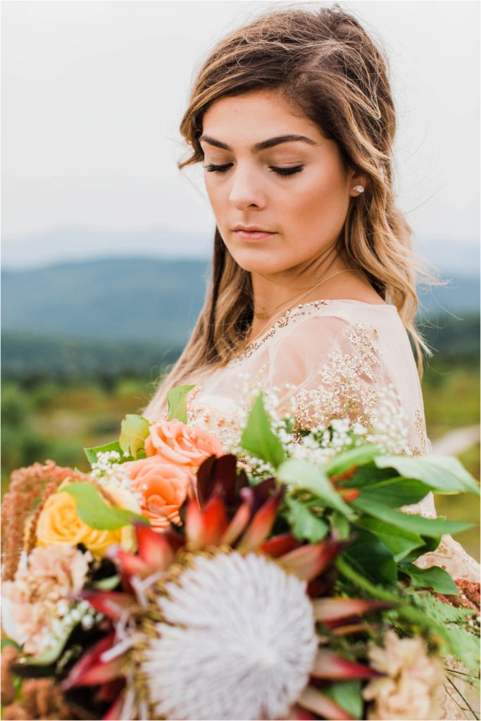 woman holding flowers on top of mountain