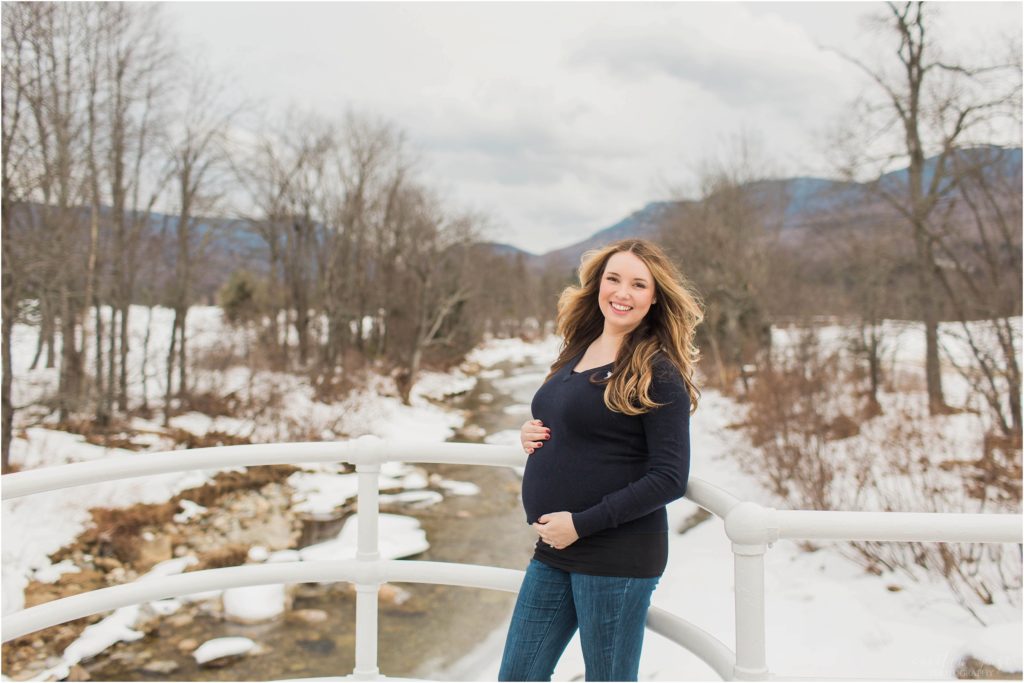 pregnant woman standing on bridge winter