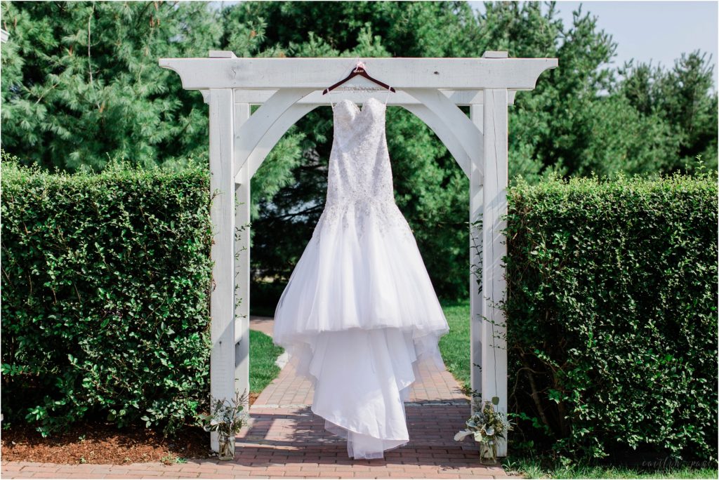 wedding dress hanging on arch