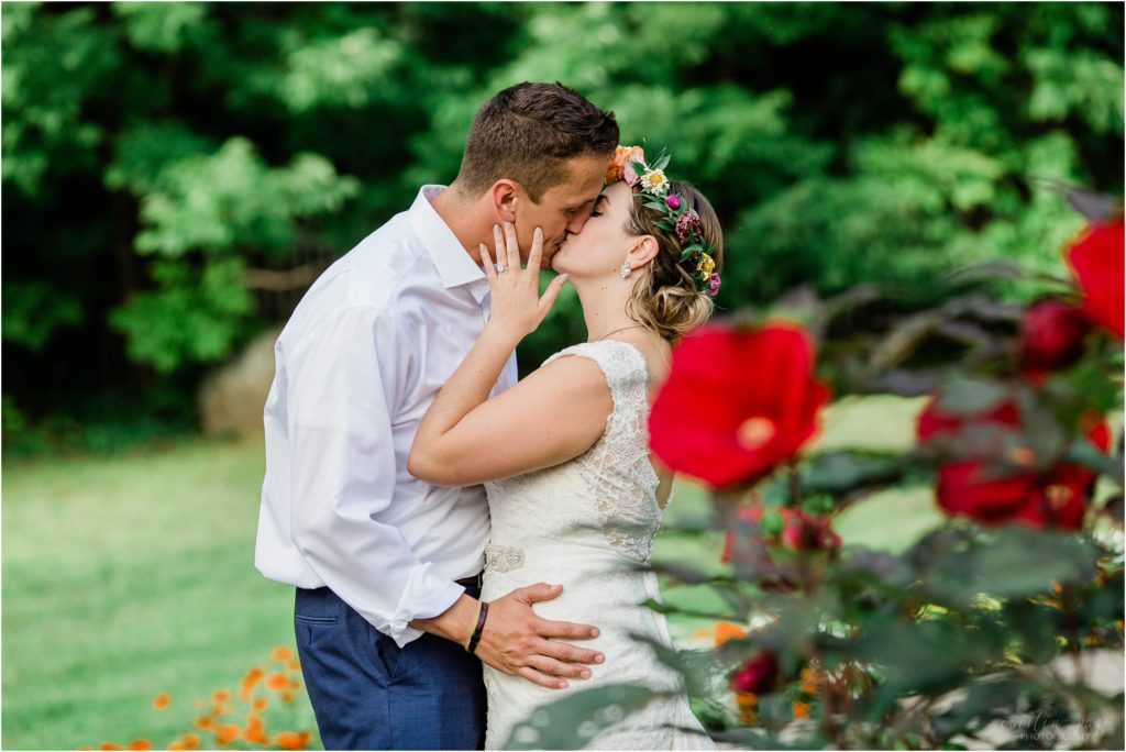bride and groom kissing red flower