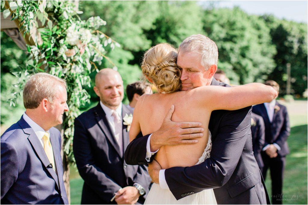 groom hugging bride wedding ceremony