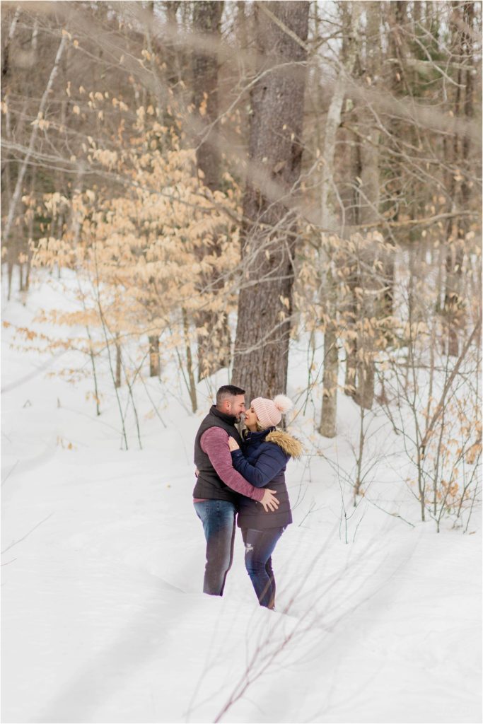man and woman kissing in snow