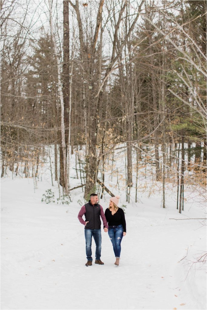 man and woman walking in winter woods