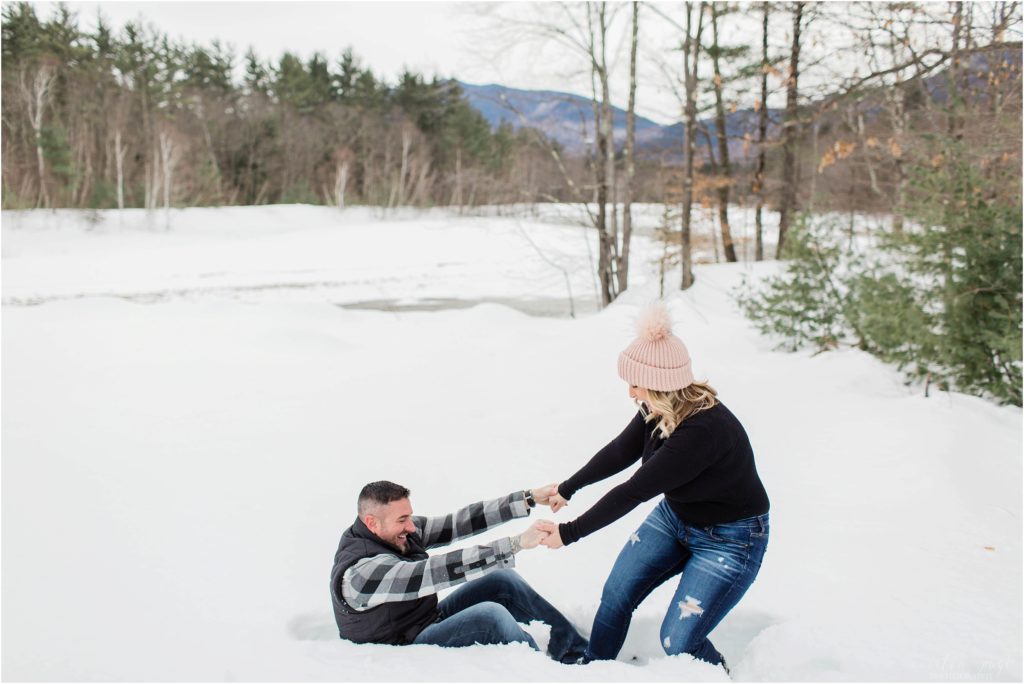 woman pulling man out of snow