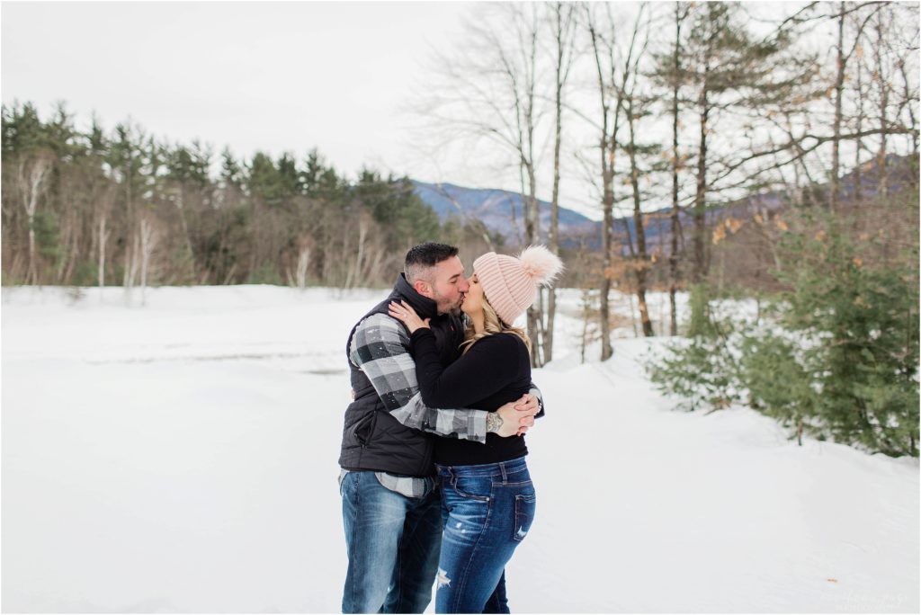 man and woman kissing in the snow