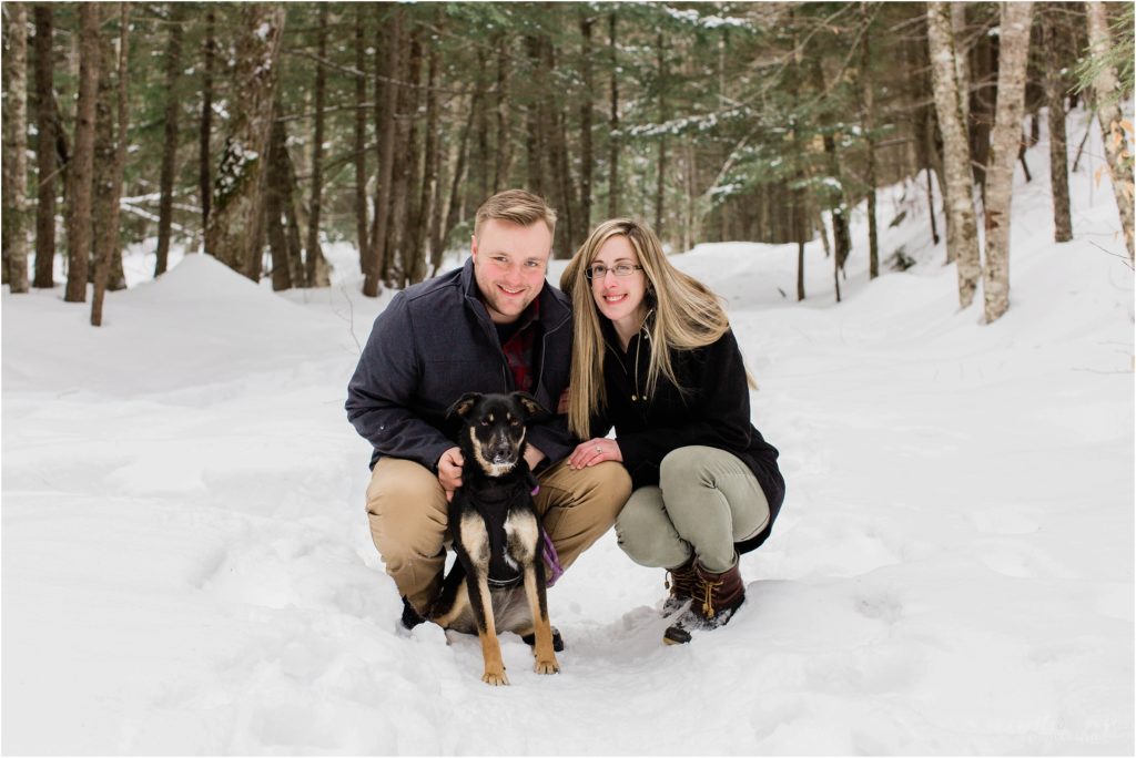 black dog with couple in snow