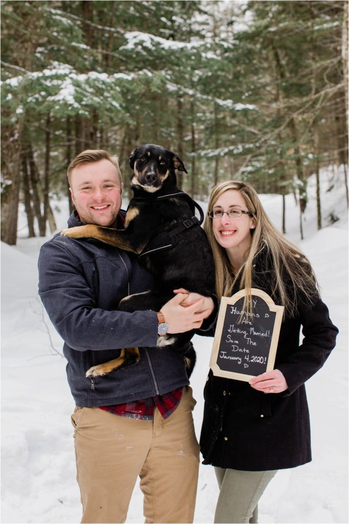 couple holding dog in snow