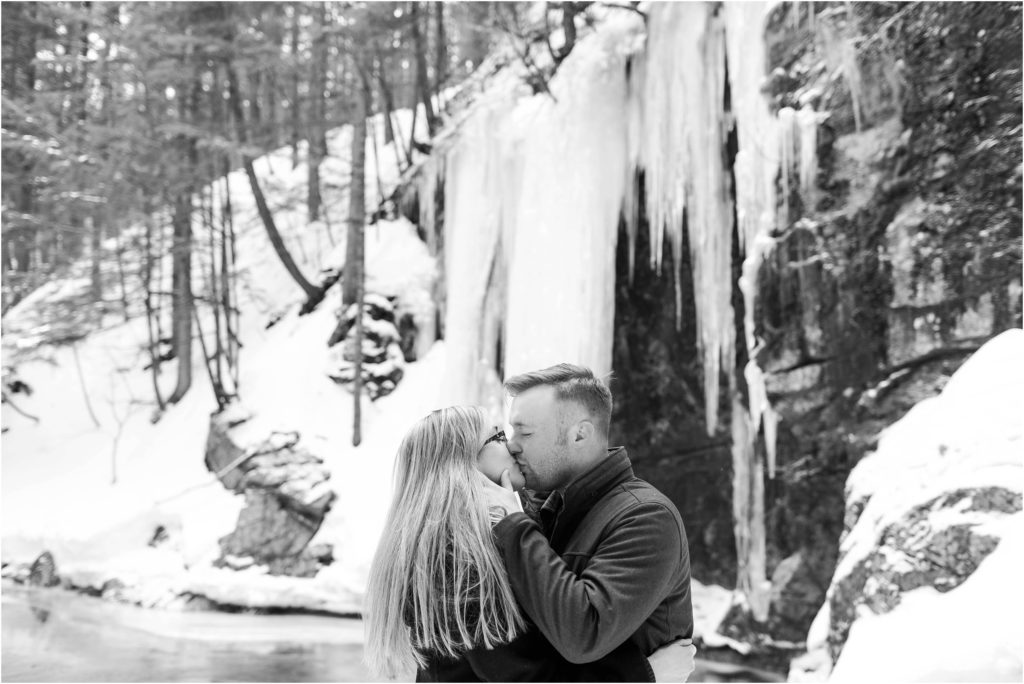 man and woman kissing in front of icicles