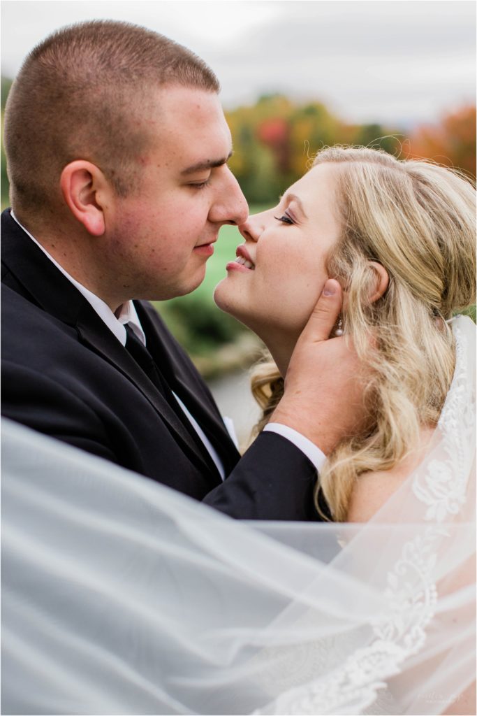 bride and groom kissing with veil at eagle mountain house 