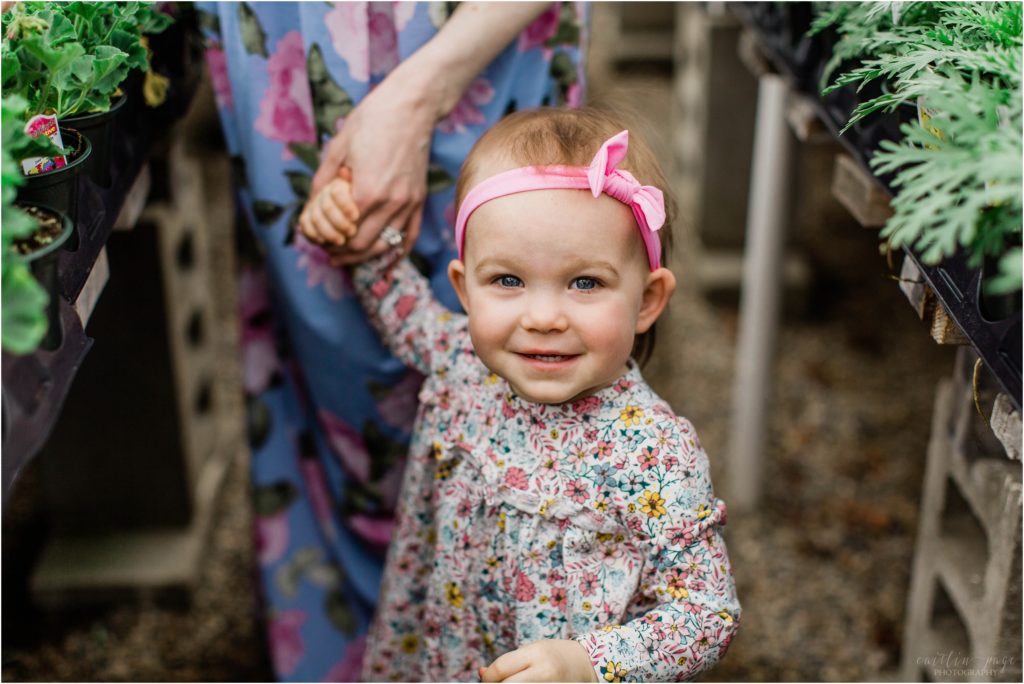 toddler girl smiling at camera in nursery