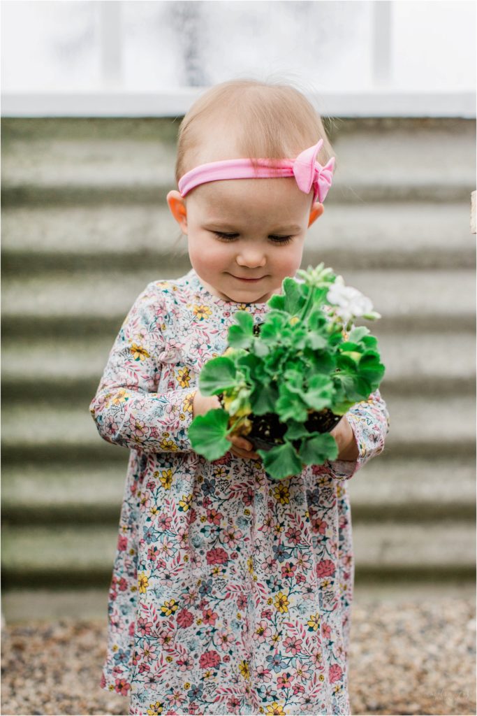 toddler girl holding potted plant
