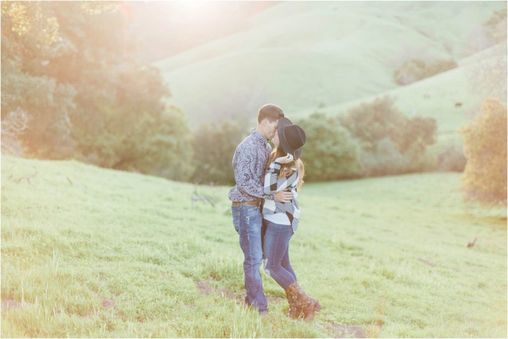 man and woman kissing cattle ranch