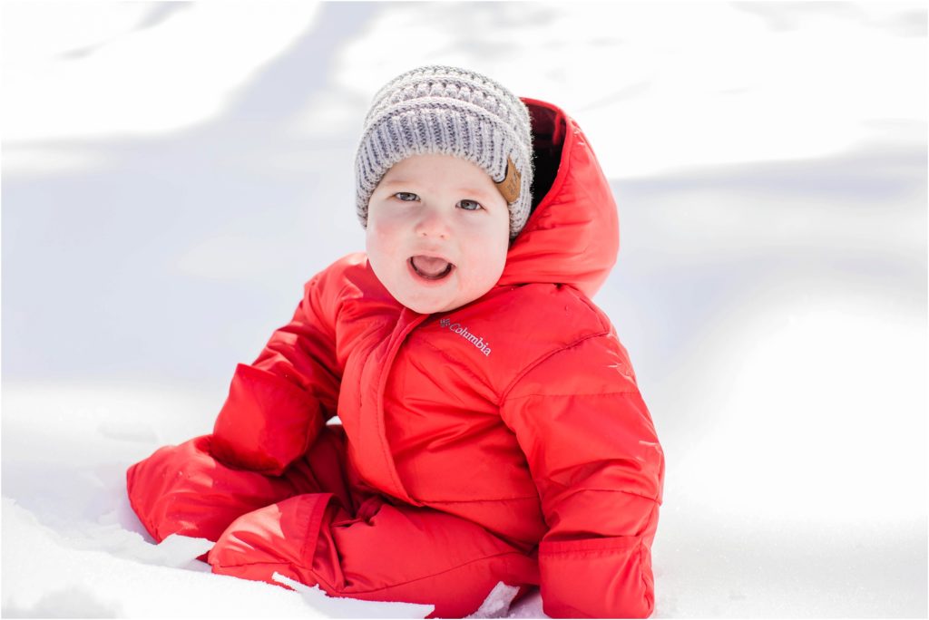 baby in red snow suit smiling