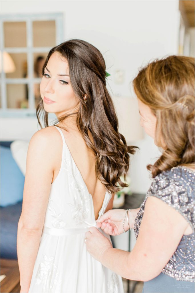 brides mom zipping her dress