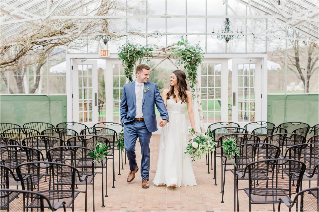 bride and groom walking down aisle in greenhouse