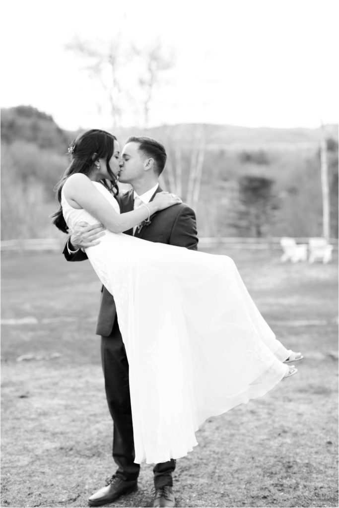 black and white portrait of groom holding bride