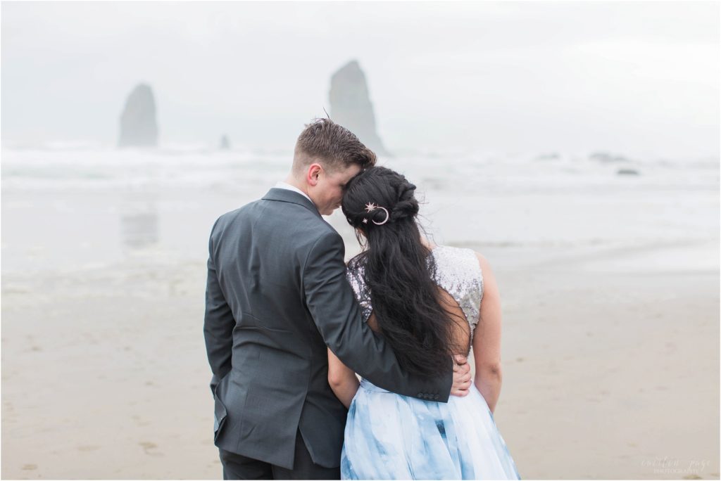 Couple snuggled together after elopement on Cannon Beach in Oregon