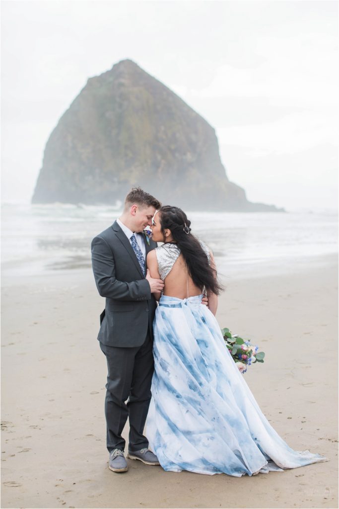 Bride and groom standing forehead to forehead on Cannon Beach Oregon