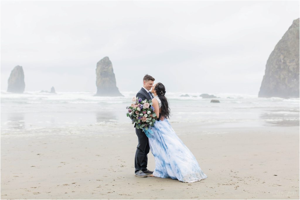 Bride and groom standing together on Cannon Beach in Oregon